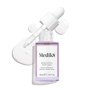 Un flacon compte-gouttes en verre violet de sérum Bakuchiol Peptides, avec le compte-gouttes retiré. Un tourbillon du sérum violet est présenté, mettant en avant la texture du produit.