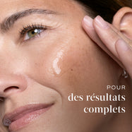Gros plan d'une femme appliquant le sérum Medik8 sur sa joue avec un texte mentionnant des résultats à spectre complet.